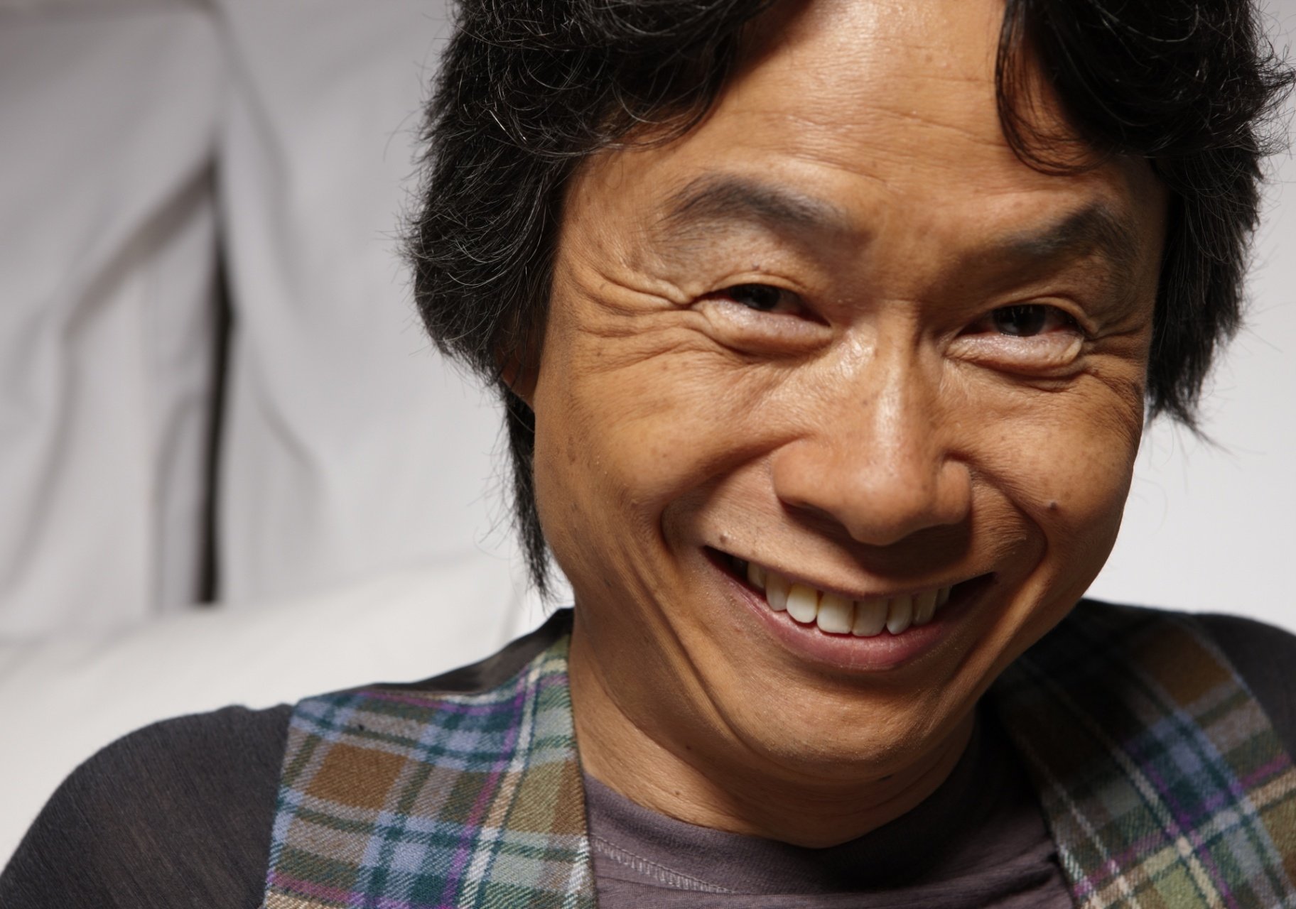 HD desktop wallpaper featuring a smiling man in a plaid shirt, suitable as a background image.