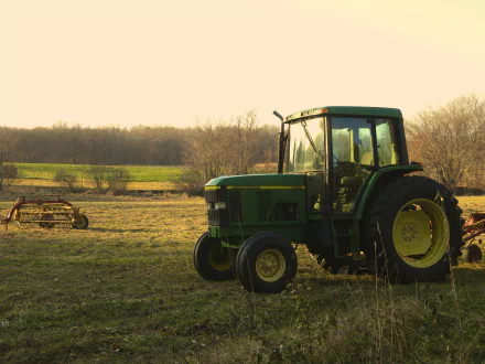 4K Ultra HD PC desktop wallpaper and background: green John Deere tractor parked in a sunlit rural field with harvest equipment in the distance.