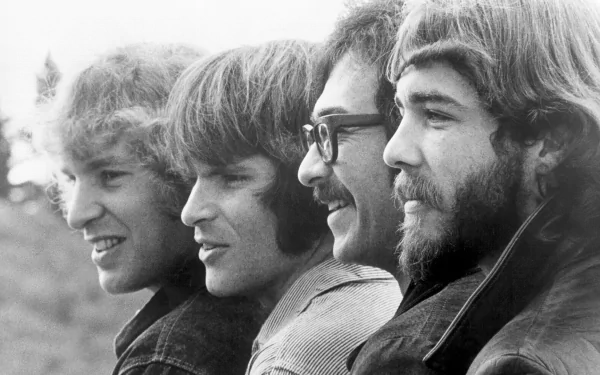 Black and white HD desktop wallpaper featuring a close-up side profile of Creedence Clearwater Revival band members lined up outdoors.
