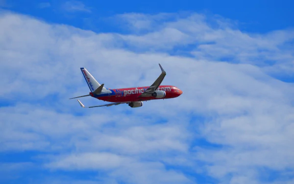 A Boeing 737 soars through a vibrant blue sky, surrounded by fluffy clouds, showcasing classic aircraft design in an eye-catching HD desktop wallpaper.
