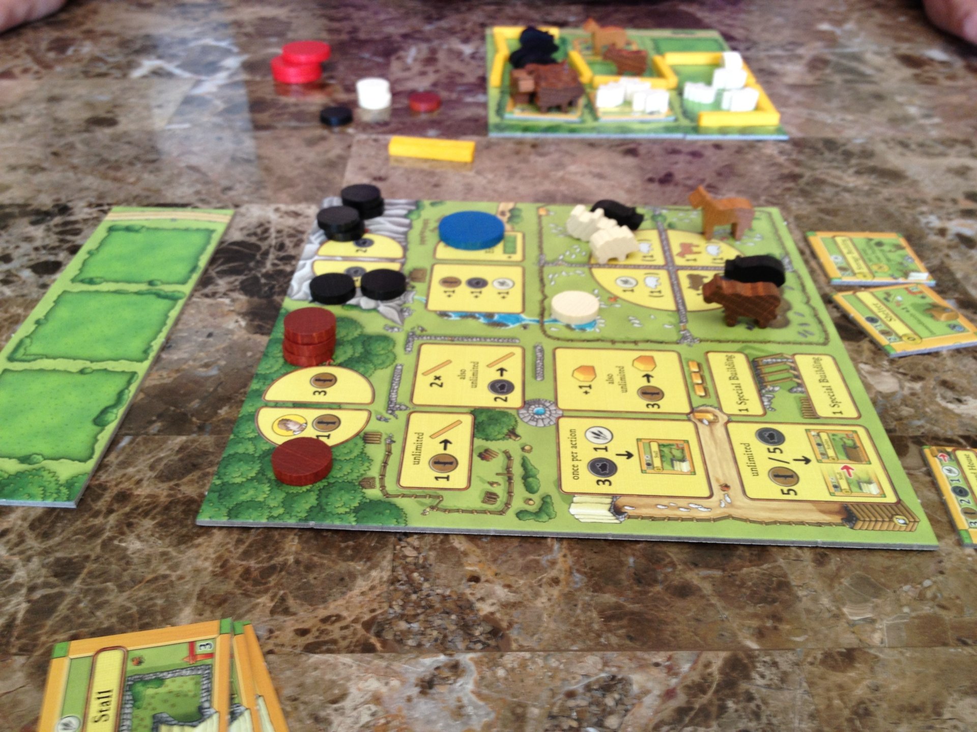 HD desktop wallpaper featuring the board game Agricola mid-play with colorful game pieces and cards on a tabletop.