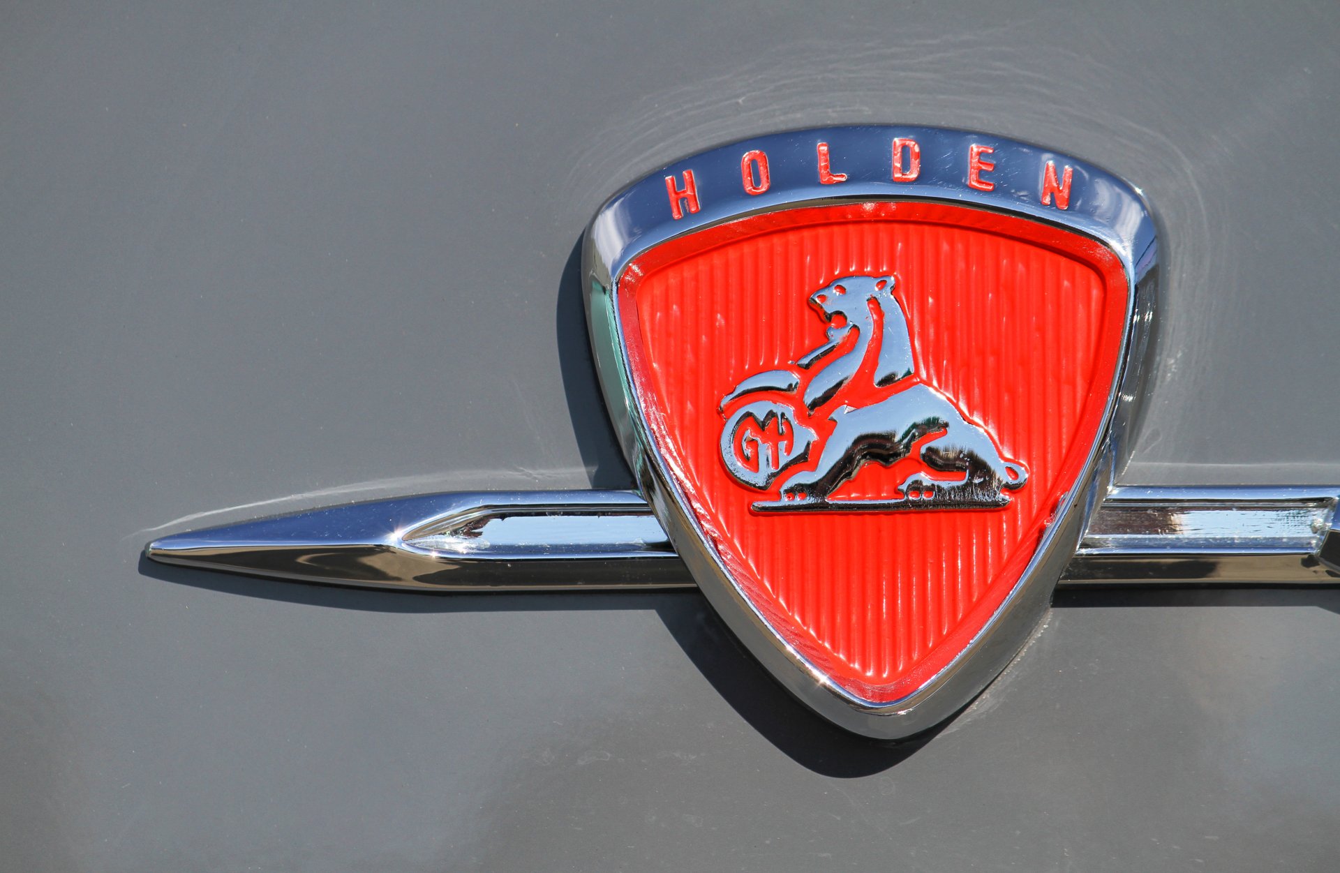 Close-up of a red and chrome Holden vehicle emblem, captured in stunning 4K Ultra HD for a vivid PC desktop wallpaper background.