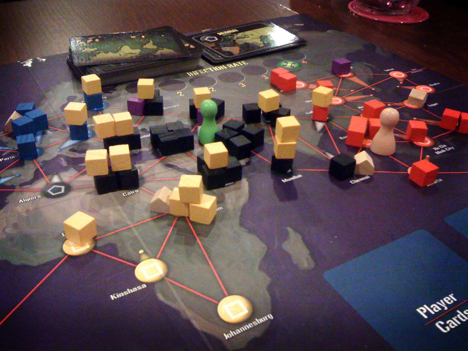HD desktop wallpaper of the board game Pandemic with colorful game pieces spread across a world map board.