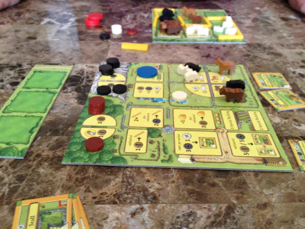 HD desktop wallpaper featuring the board game Agricola mid-play with colorful game pieces and cards on a tabletop.