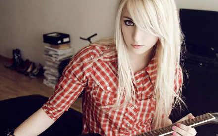 HD desktop wallpaper featuring a woman with white hair modeling in a red plaid shirt, holding a guitar in a stylishly cluttered room.