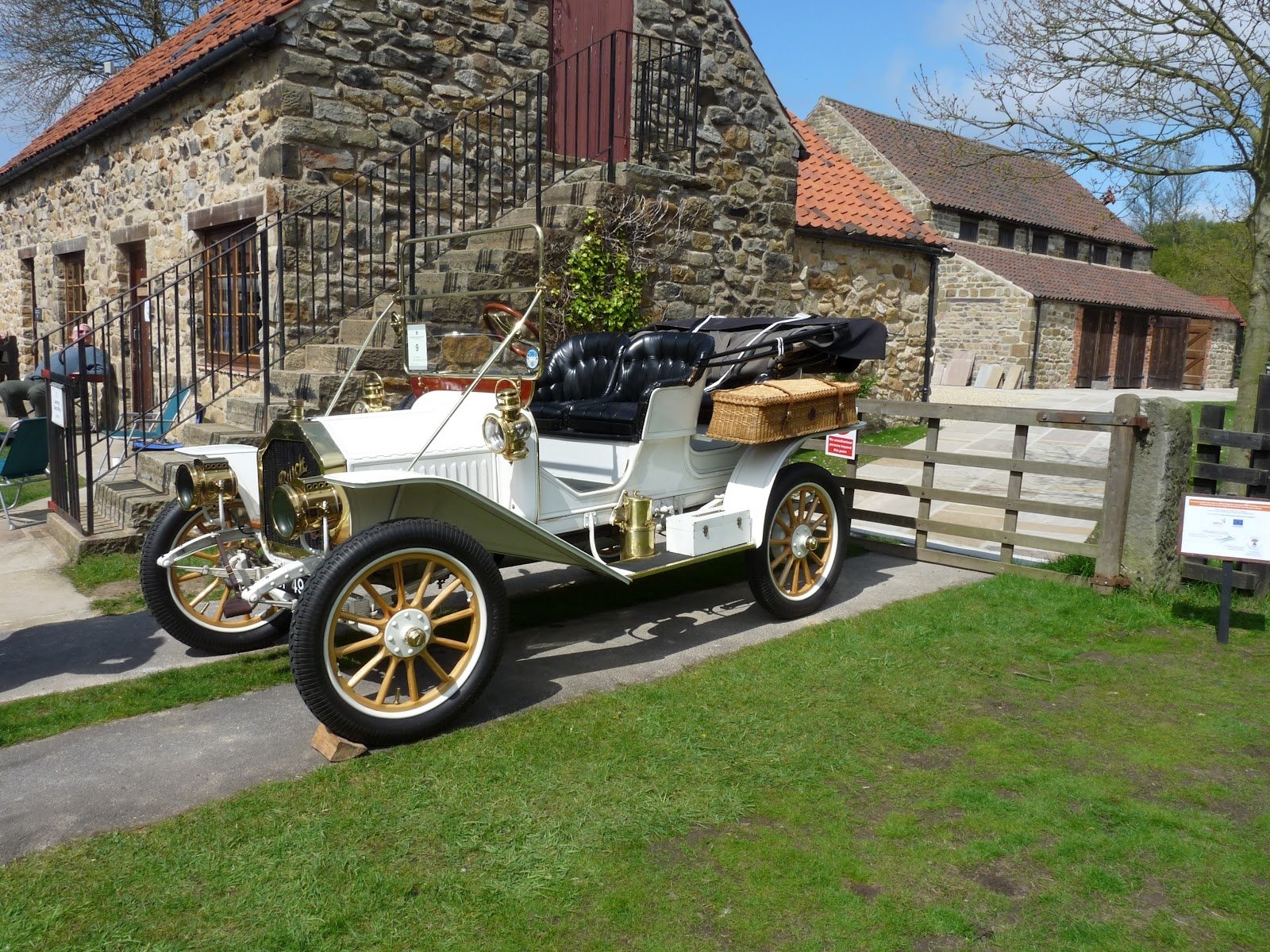 Vintage white Buick Model 10 vehicle displayed outdoors near stone buildings, captured in an HD desktop wallpaper and background.
