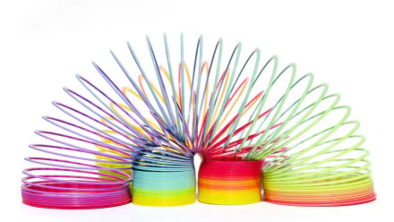 A vibrant, colorful slinky toy arranged in an arch on a white background, designed as an HD PC desktop wallpaper and background.