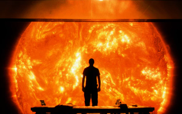 HD PC desktop wallpaper: dramatic scene from the movie Sunshine (2007) showing a silhouetted figure standing before an enormous glowing sun.