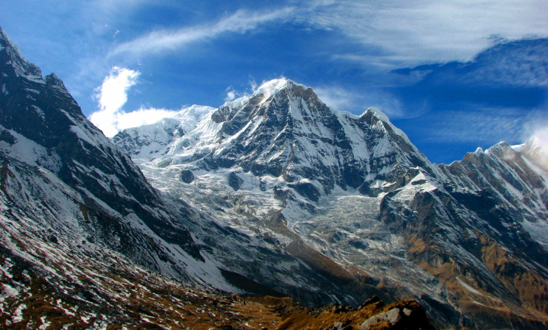 A stunning view of the Himalayas, showcasing majestic snow-capped peaks under a vibrant blue sky. This HD wallpaper captures the beauty of nature in breathtaking detail.