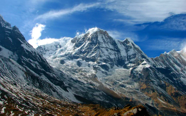 A stunning view of the Himalayas, showcasing majestic snow-capped peaks under a vibrant blue sky. This HD wallpaper captures the beauty of nature in breathtaking detail.
