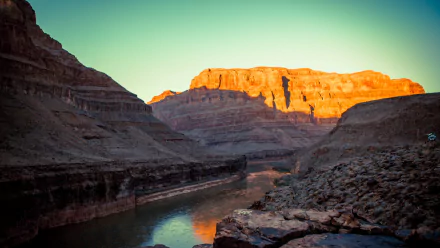 A stunning view of the Grand Canyon at sunset, showcasing dramatic rock formations and a winding river, captured in vibrant colors. This 4K Ultra HD image serves as an impressive desktop wallpaper.