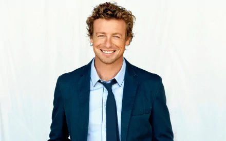 HD desktop wallpaper featuring celebrity Simon Baker smiling confidently against a plain white background.