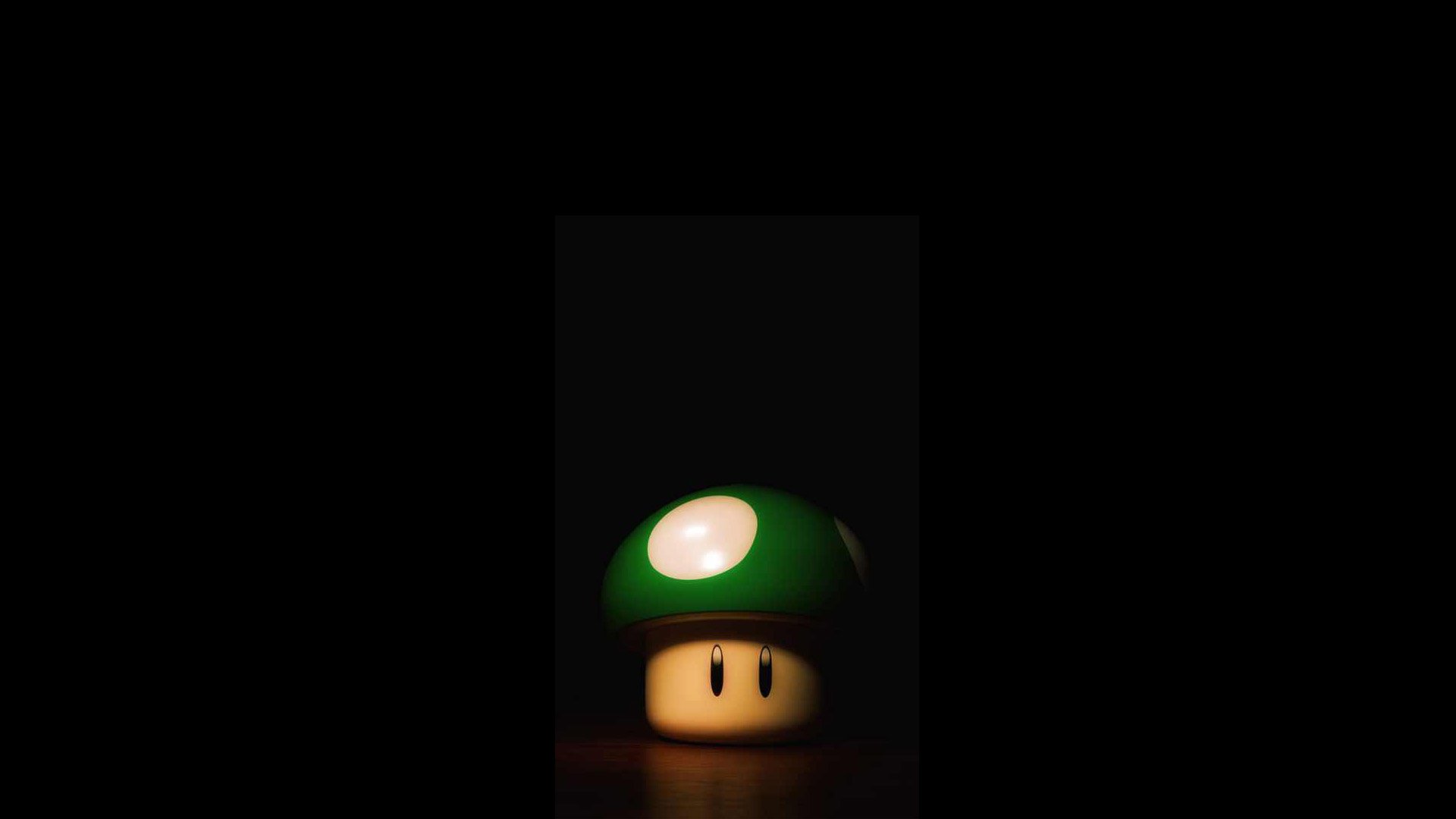 HD PC desktop wallpaper featuring a green 1-Up mushroom from the Mario video game series against a dark background.
