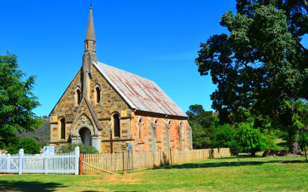 Old St Paul's Presbyterian Church with a weathered fence and lush trees under a clear blue sky, captured in HD for a desktop wallpaper background.