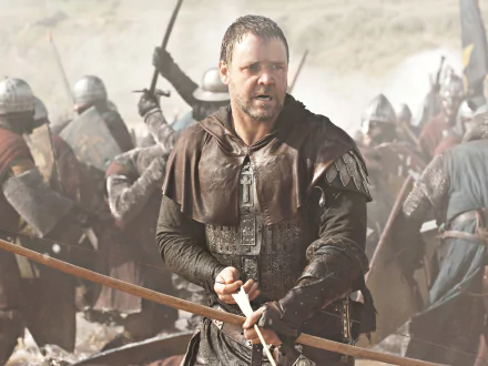 2K Quad HD PC desktop wallpaper: actor portraying Robin Hood in the 2010 movie, gripping a sword on a foggy battlefield surrounded by armored soldiers.