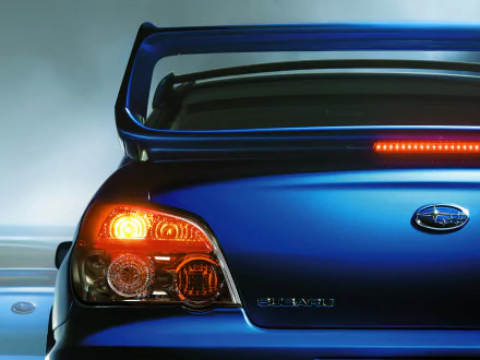 A vibrant HD wallpaper showcasing the rear of a Subaru vehicle, highlighting its sleek design and distinctive taillights against a dynamic background.