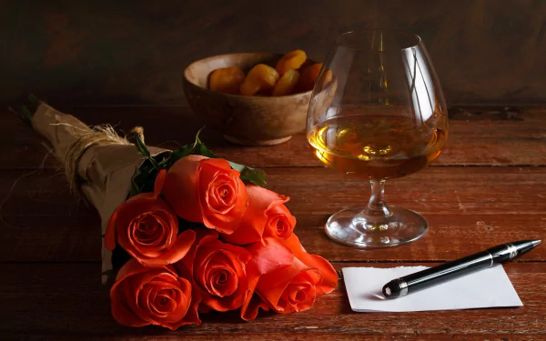 HD desktop wallpaper featuring a still life of vibrant orange roses, a glass of amber liquor, a bowl of nuts, and a pen on a wooden table.