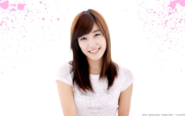 HD PC desktop wallpaper featuring a smiling member of Girls' Generation (SNSD) with a soft pink splatter background, representing music and the group's charm.