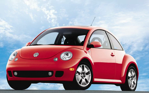 Red Volkswagen Beetle parked under a bright blue sky, showcased as an HD PC desktop wallpaper and background.
