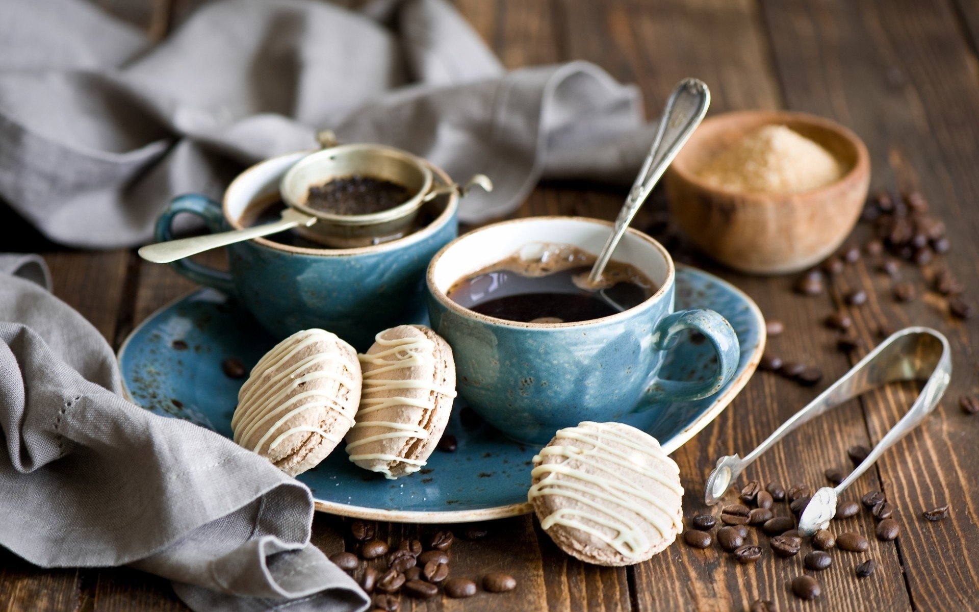 HD desktop wallpaper featuring a coffee cup, biscuits on a blue plate, and a wooden bowl of sugar on a rustic wooden table with a gray cloth.