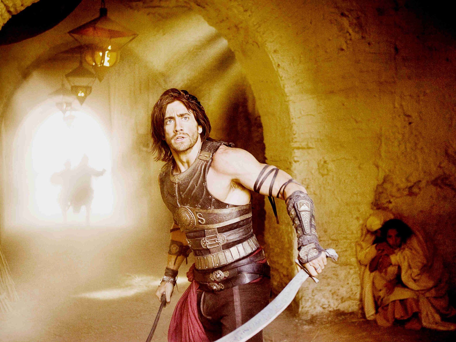 Prince Dastan, portrayed by Jake Gyllenhaal, stands ready for action in this HD wallpaper from the movie Prince of Persia: The Sands of Time, set in a mystical, ancient backdrop.