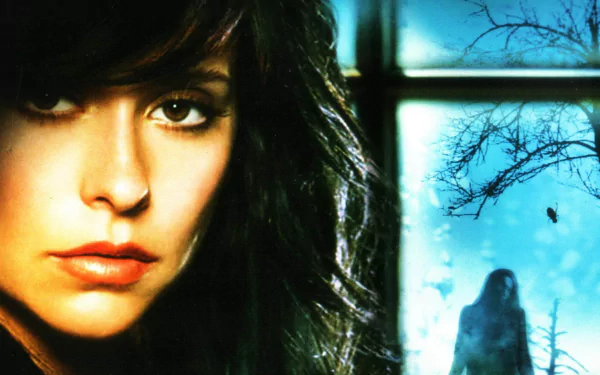 HD desktop wallpaper: close-up of a dark-haired woman beside a misty blue scene with a distant ghostly figure and bare trees, evoking the TV show Ghost Whisperer.