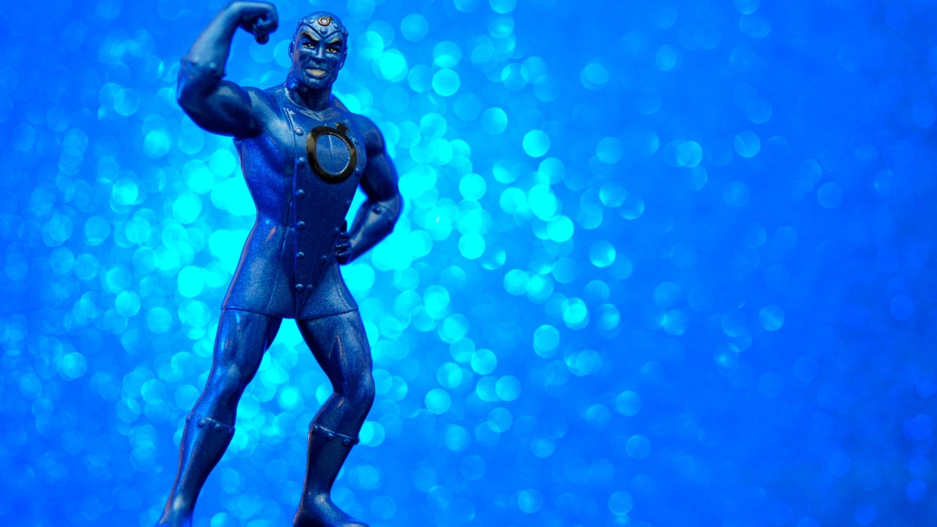 DC Comics Metal Men figure in heroic pose on a blue bokeh field — 2K Quad HD PC desktop wallpaper, comic book style background.