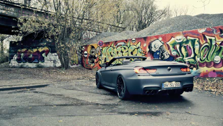 HD PC desktop wallpaper/background: gray BMW M6 Cabriolet vehicle parked by colorful graffiti in an urban lot, spotlighting the BMW M6 convertible against a street-art backdrop.