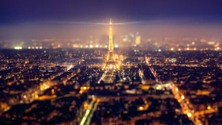 A stunning HD desktop wallpaper of Paris at night, showcasing the illuminated Eiffel Tower amidst a sprawling cityscape. The iconic monument stands majestically against the backdrop of the vibrant city lights.