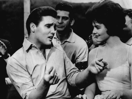 Black and white HD desktop wallpaper from the movie Kid Galahad, featuring a lively scene with a man and woman engaged in conversation.