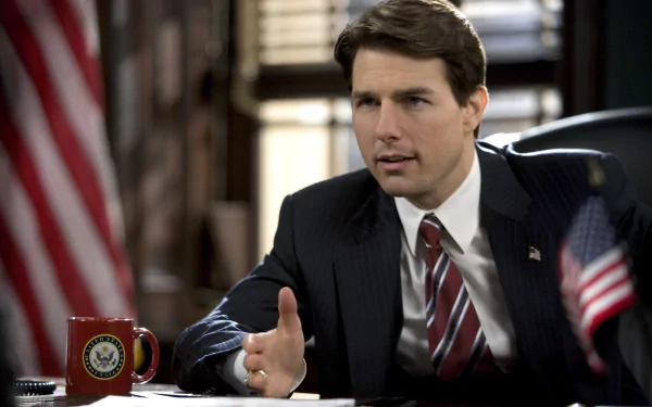 HD PC desktop wallpaper featuring a scene from the movie Lions for Lambs, showing a man in a suit speaking at a desk with American flags nearby.