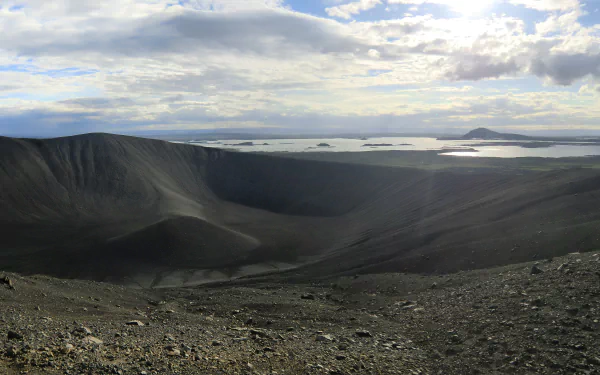 Icelandic volcanic crater and barren ash slopes descending to coastal islands under a dramatic cloudy sky — 5K Ultra HD PC desktop wallpaper background.