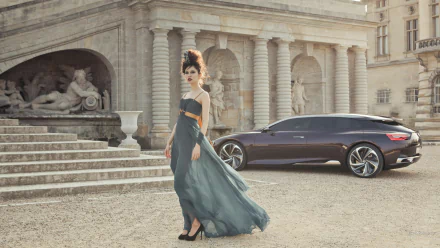 HD PC desktop wallpaper: a model in a flowing gown stands by the Citroën Numero 9 Concept vehicle parked before a classical stone building.