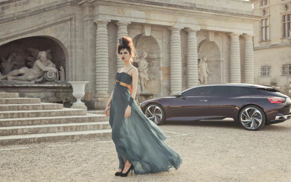 HD PC desktop wallpaper: a model in a flowing gown stands by the Citroën Numero 9 Concept vehicle parked before a classical stone building.