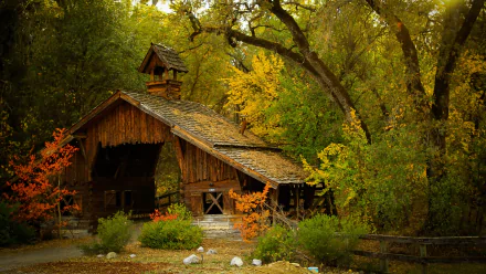 HD wallpaper of a rustic covered bridge surrounded by lush autumn foliage, embodying a serene, picturesque setting.