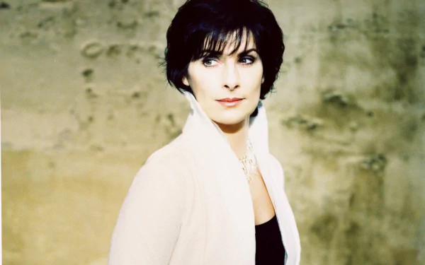 HD PC desktop wallpaper: elegant portrait of a female new-age singer, serene expression and soft lighting against a textured wall — music-themed background.