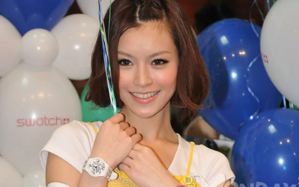 Smiling young woman with shoulder-length brown hair and a white wristwatch, surrounded by blue and white balloons — HD PC desktop wallpaper/background.