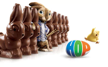 HD PC desktop wallpaper featuring the Easter Bunny from the movie Hop, standing among chocolate bunnies with a colorful egg and a yellow chick nearby.