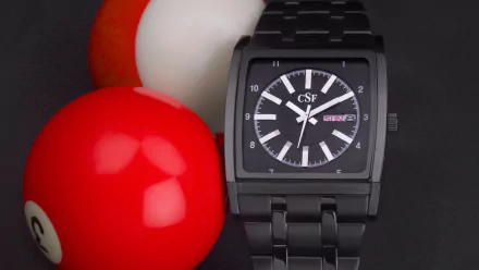 HD desktop wallpaper featuring a man-made CSF Time watch with a black metal band, positioned next to red and white billiard balls.