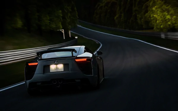 Lexus LFA speeding on a dark, winding road surrounded by trees, captured in this HD desktop wallpaper showcasing the vehicle's sleek design and aerodynamic features.