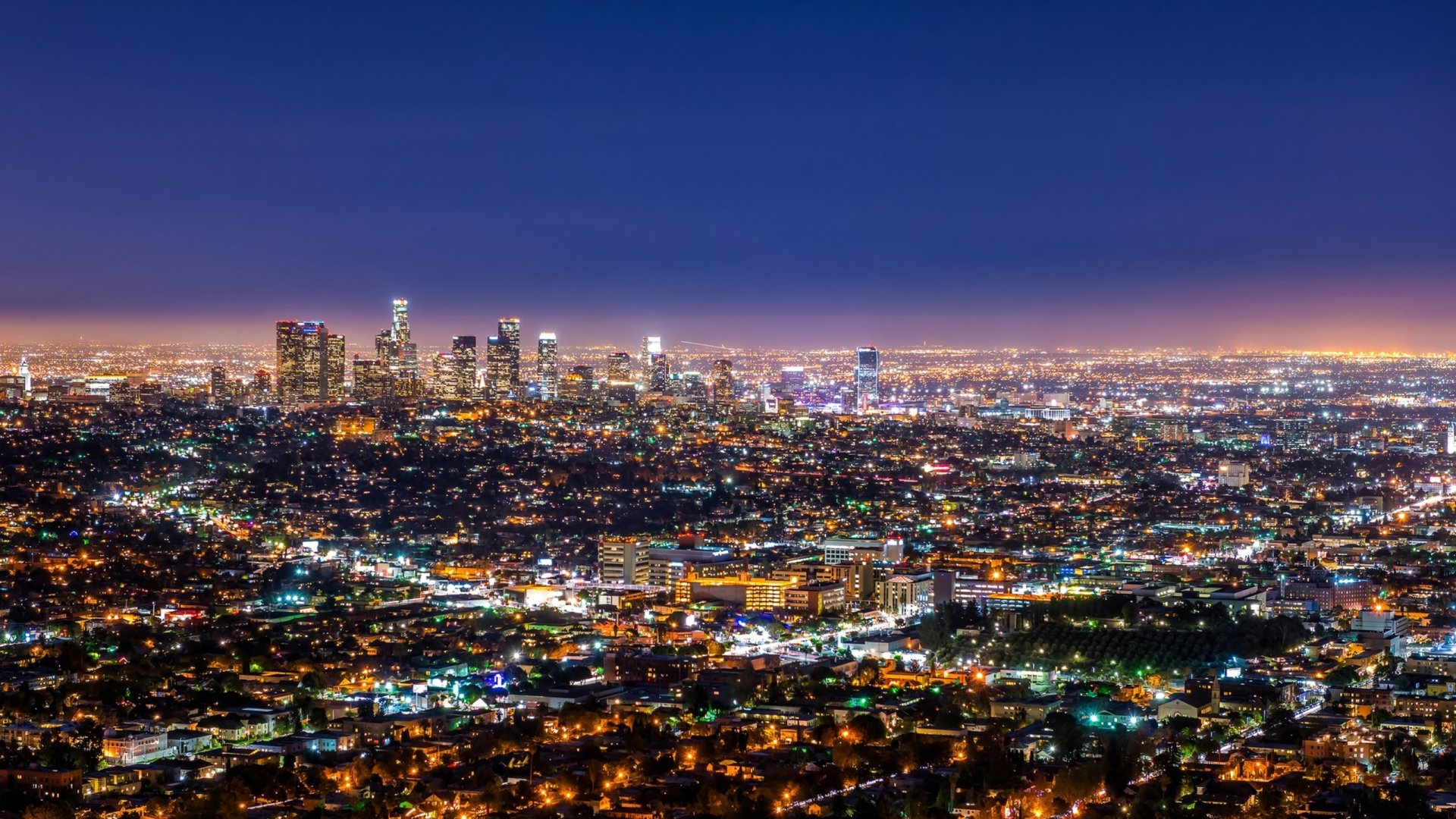 Nighttime HD wallpaper of Los Angeles cityscape in the United States, showcasing a vast spread of man-made lights under a deep blue sky.