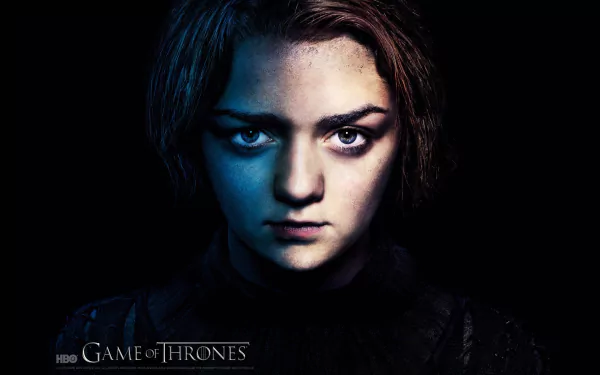 HD wallpaper featuring Maisie Williams as Arya Stark from the TV show Game of Thrones, showcasing a dramatic close-up with striking lighting and intense expression.