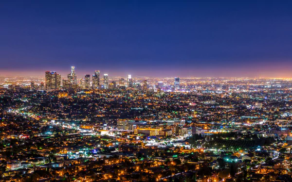 Nighttime HD wallpaper of Los Angeles cityscape in the United States, showcasing a vast spread of man-made lights under a deep blue sky.
