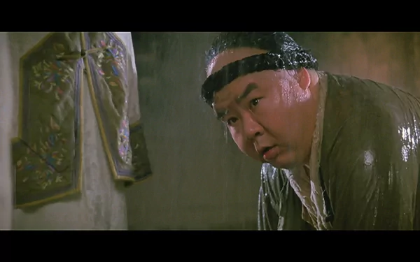 HD PC desktop wallpaper from the movie Once Upon a Time in China: a soaked, headband-wearing man leans forward in a dim, ornate interior.