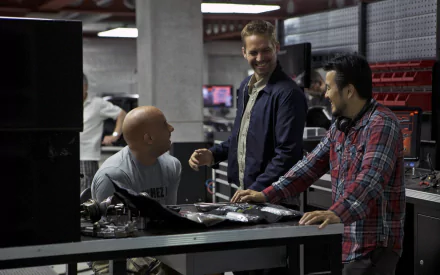 A behind-the-scenes moment from *Fast & Furious 6*, featuring Vin Diesel as Dominic Toretto and Paul Walker as Brian O'Conner, captured while working in a tech-filled setting.