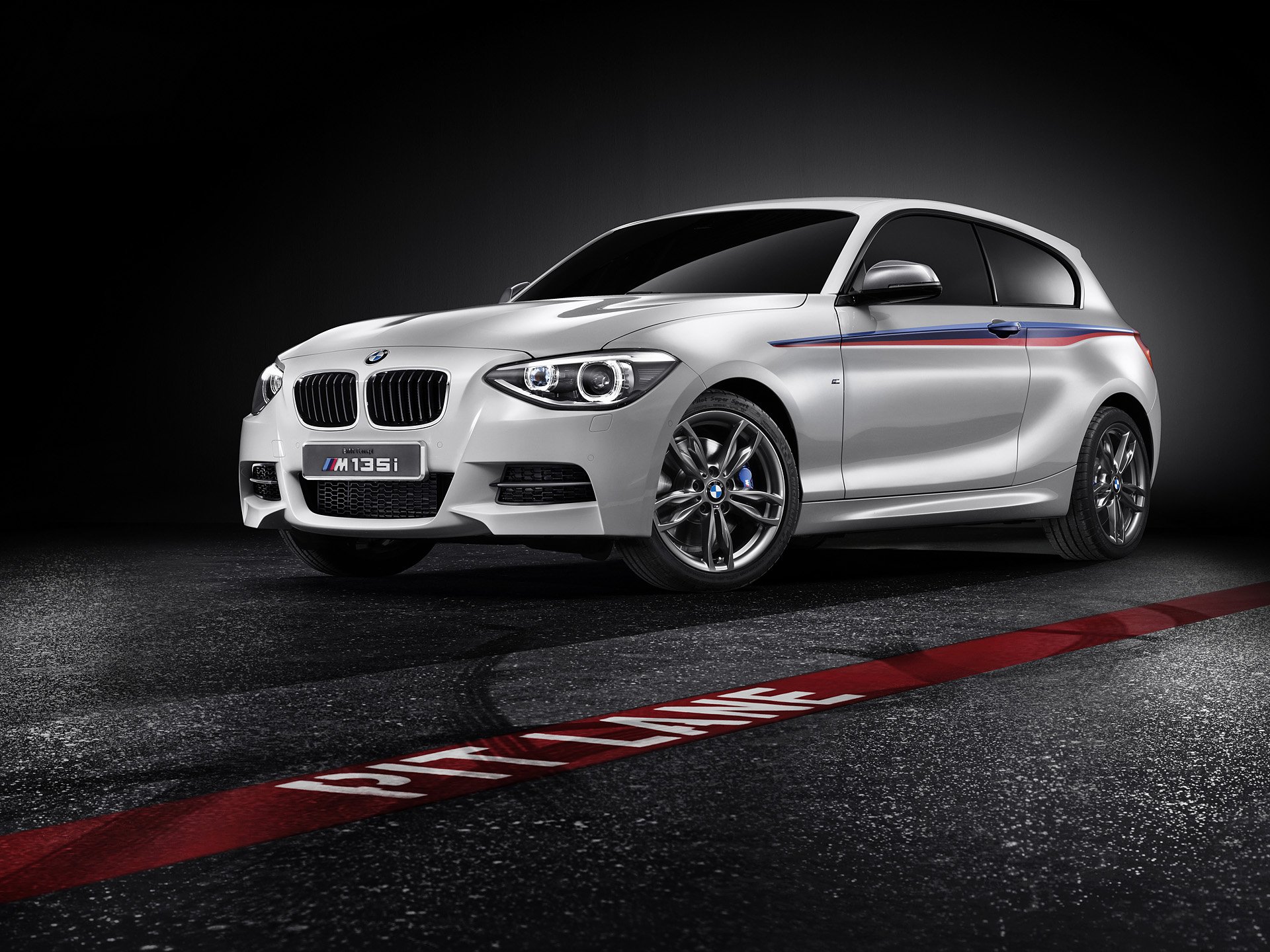 Silver 2012 BMW Concept M135i hatchback with M-stripe accents, studio-lit on asphalt — HD PC desktop wallpaper background.
