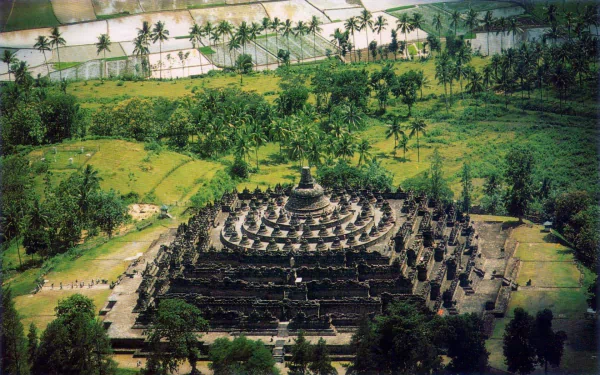 Aerial view of the religious Borobudur temple complex surrounded by lush green landscape, captured as an HD PC desktop wallpaper background.