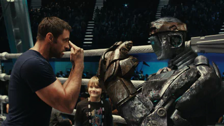 A dynamic scene from the movie *Real Steel*, featuring Hugh Jackman facing off against a robot, with a young boy looking on, showcased as a vibrant HD desktop wallpaper.