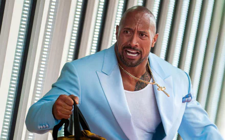 Dwayne Johnson in a blue suit portrays a tense moment in the film Pain & Gain. This HD wallpaper captures his intense expression and dynamic energy.