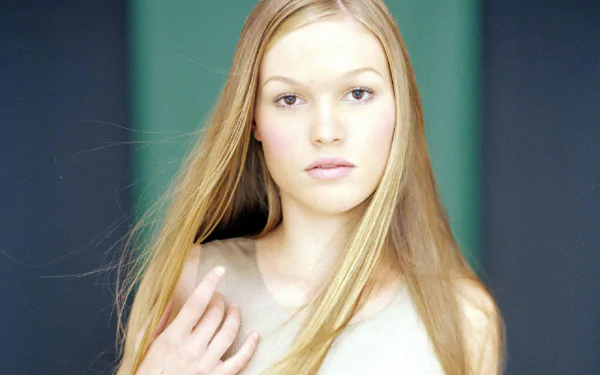 A stunning HD desktop wallpaper featuring Julia Stiles, showcasing her natural beauty with long, flowing hair and a serene expression against a softly colored background.